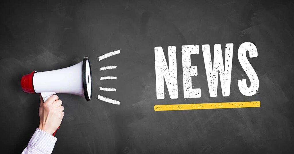 En hånd, der holder en megafon med ordet "nyheder"