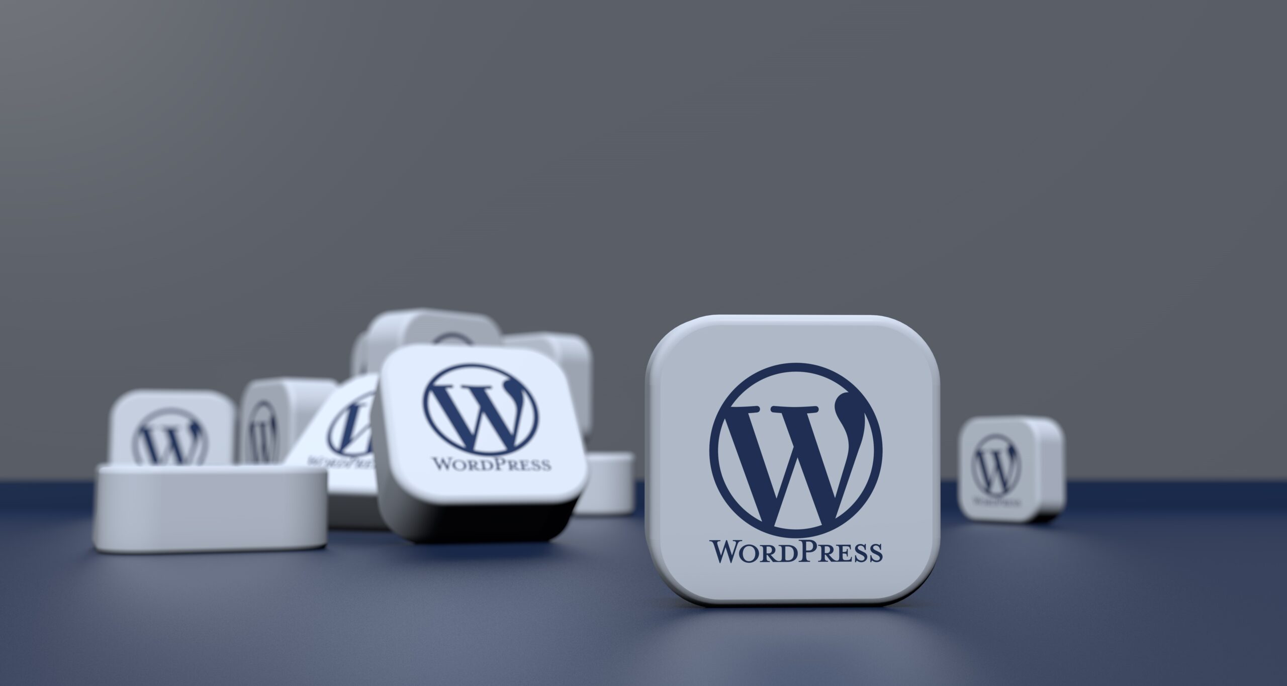 Flere 3D-kuber, der viser WordPress-logoet, er spredt på en mørkeblå overflade med en almindelig grå baggrund, der fremkalder den sømløse integration, der er mulig med værktøjer som WP-CLI og terminalkommandoer.