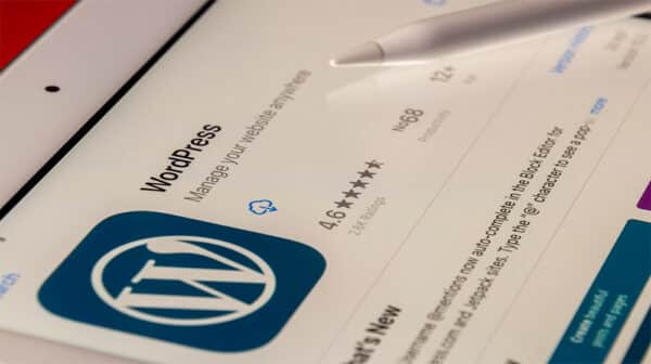 En tabletskærm viser WordPress' app-side i en app-butik med logo, bedømmelse og en stylus i nærheden - perfekt til FutureNode.dk-brugere, der udforsker nye digitale værktøjer.